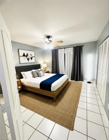 Bedroom featuring light tile patterned flooring, a closet, and a ceiling fan