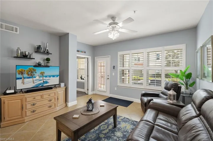 Living area featuring light tile patterned flooring and a ceiling fan