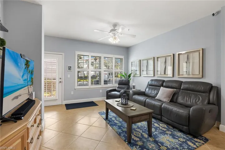 Living room featuring light tile patterned floors and a ceiling fan
