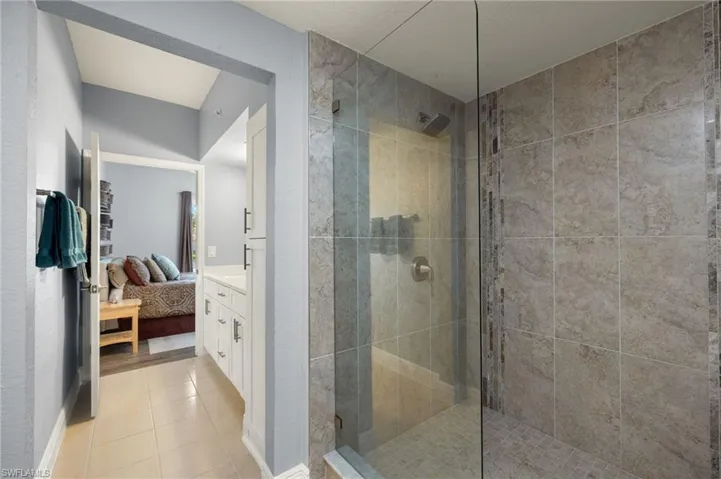 Ensuite bathroom with a walk in shower and light tile patterned flooring