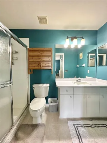 Bathroom with tile patterned flooring, vanity, and walk in shower