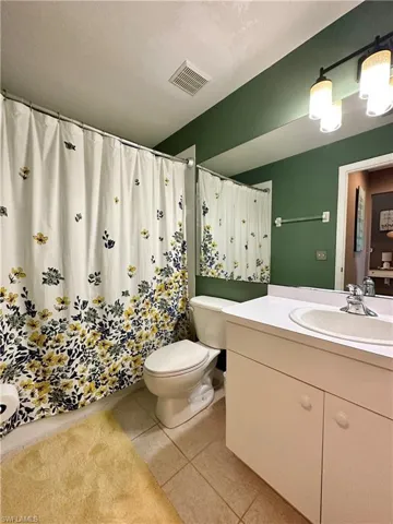 Bathroom featuring vanity, toilet, and tile patterned flooring