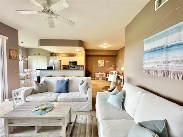 Carpeted living room featuring ceiling fan