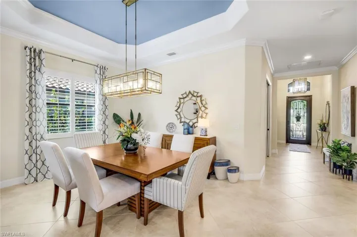 Dining area with a tray ceiling, crown molding, and new chandelier