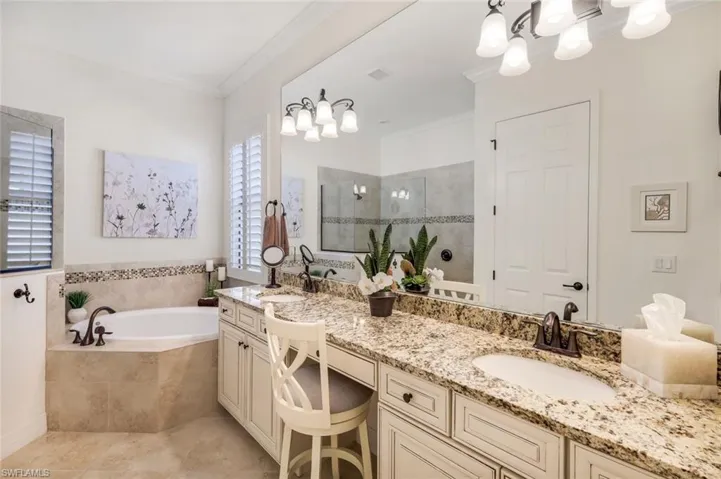 Primary bath with dual sinks, soaking tub and doorless shower.