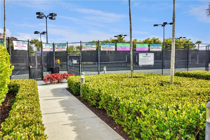 View of tennis court featuring a gate