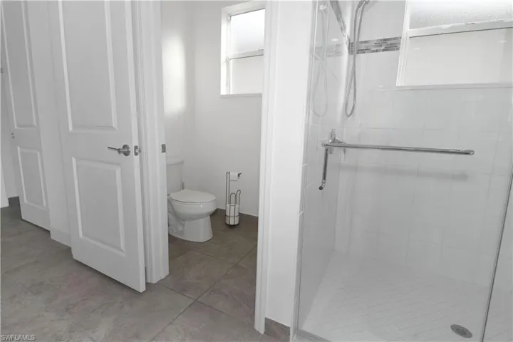 Full bath featuring a shower stall and light tile patterned floors