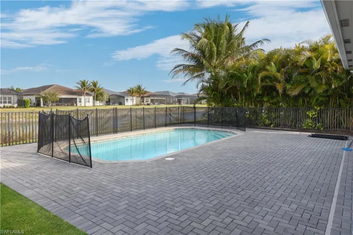 View of pool featuring patio surround, a residential view, and a fenced backyard