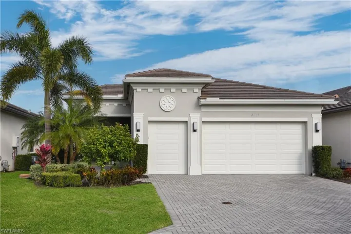 Mediterranean / spanish home with decorative driveway, a garage, stucco siding, and a tiled roof