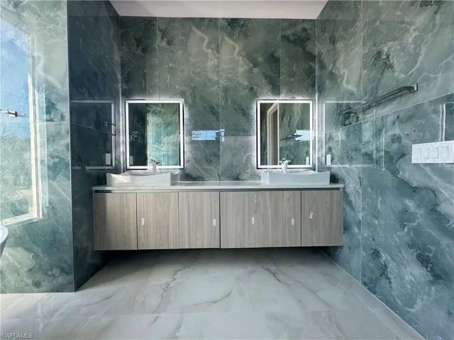 Bathroom with vanity and tile walls