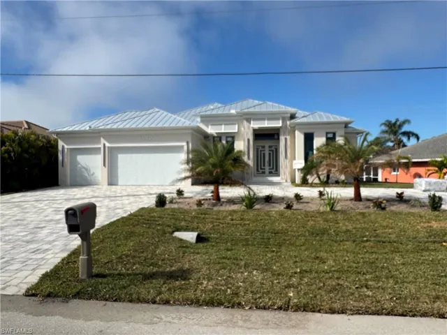 View of front of house with a garage and a front lawn