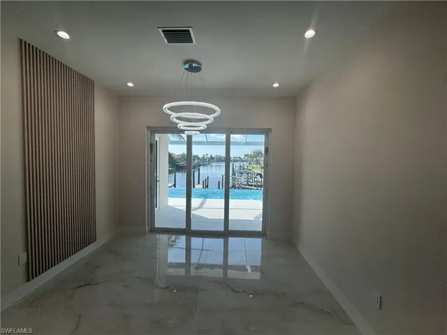 Unfurnished room with a water view and a chandelier