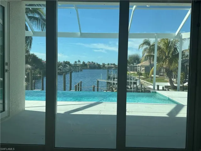 View of swimming pool featuring a water view and a dock