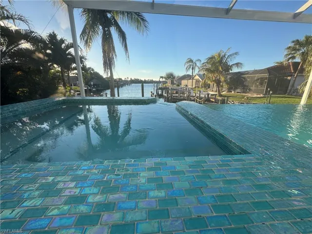 View of swimming pool featuring a boat dock and a water view