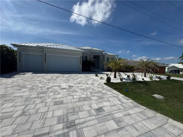 View of front facade featuring a garage and a front yard