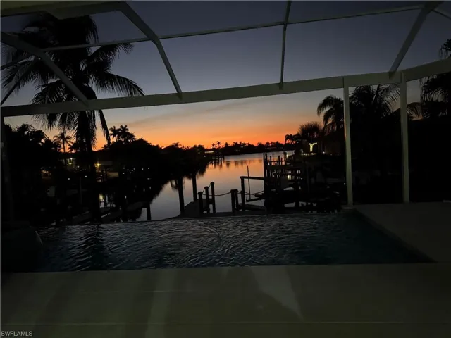 View of dock with a water view and a lanai