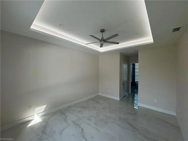 Spare room with ceiling fan and a raised ceiling