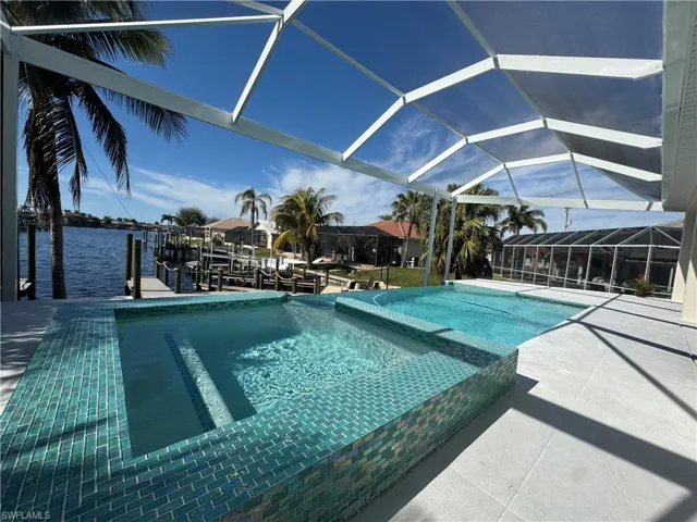 View of pool featuring a water view, a boat dock, a patio area, and a lanai