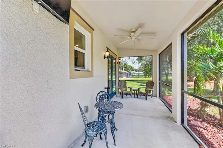 Screened patio featuring a ceiling fan, outdoor lighting, and concrete flooring