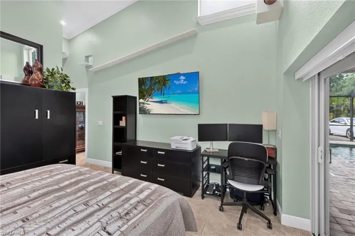 Vaulted ceilings with crown molding, natural light, tile flooring, and a sliding glass door