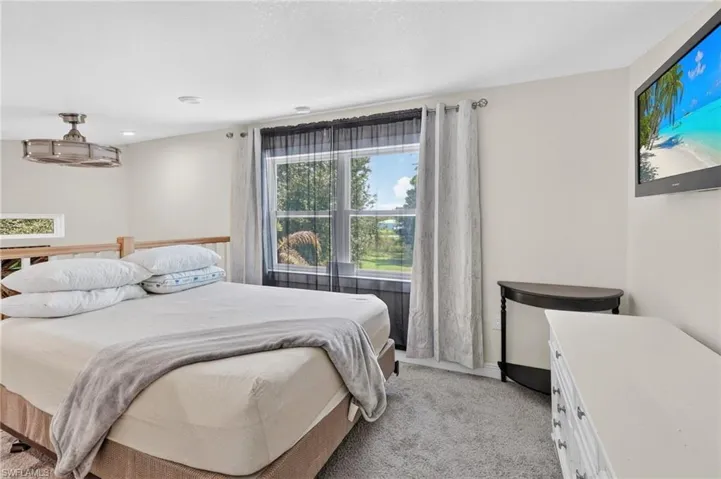 Carpeted flooring with a large window, recessed lighting, and a ceiling fan