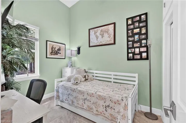 Recessed window with white blinds, light green wall finishes, and tile flooring