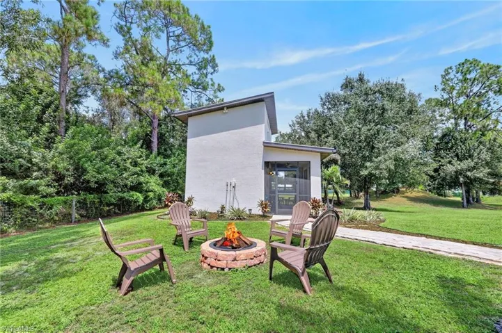 Screened entry, contemporary exterior architecture, brick fire pit, and mature perimeter landscaping
