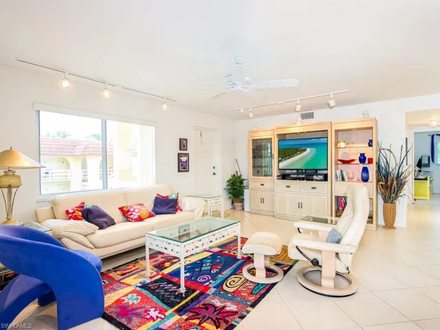Living area featuring rail lighting, light tile patterned flooring, and ceiling fan
