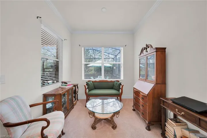 Sitting room with light carpet and crown molding