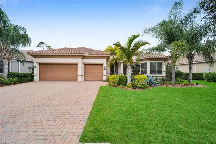 Mediterranean / spanish-style house with a front yard, decorative driveway, stucco siding, a garage, and a tiled roof