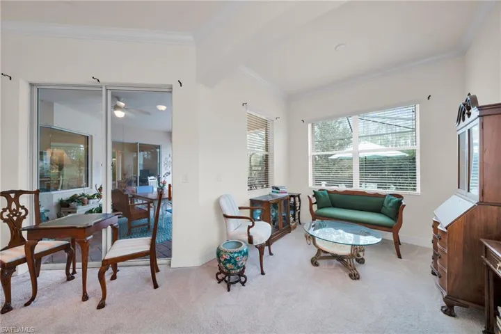 Living area with crown molding, light carpet, and a ceiling fan