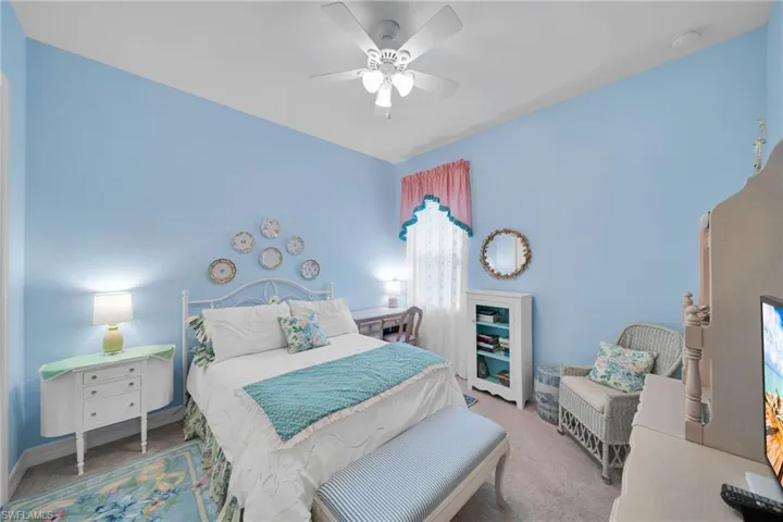 Carpeted bedroom with a ceiling fan