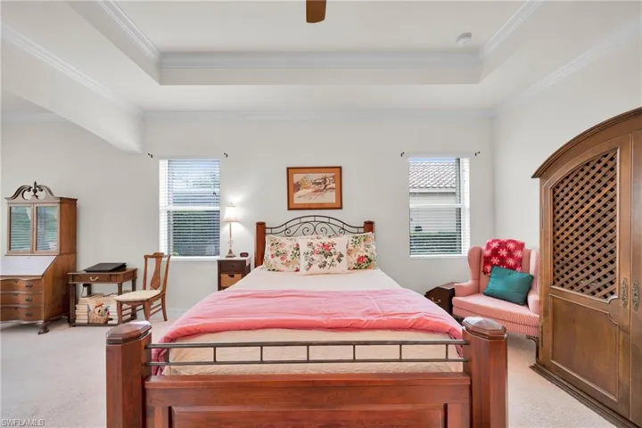 Bedroom featuring light carpet, multiple windows, a ceiling fan, and crown molding