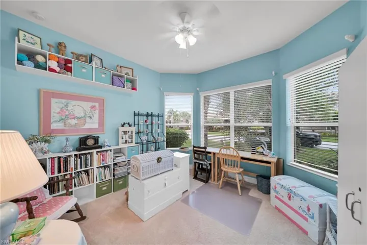 Carpeted home office featuring ceiling fan