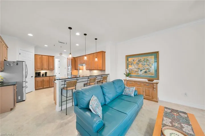 Living area with crown molding, recessed lighting, and light tile patterned floors
