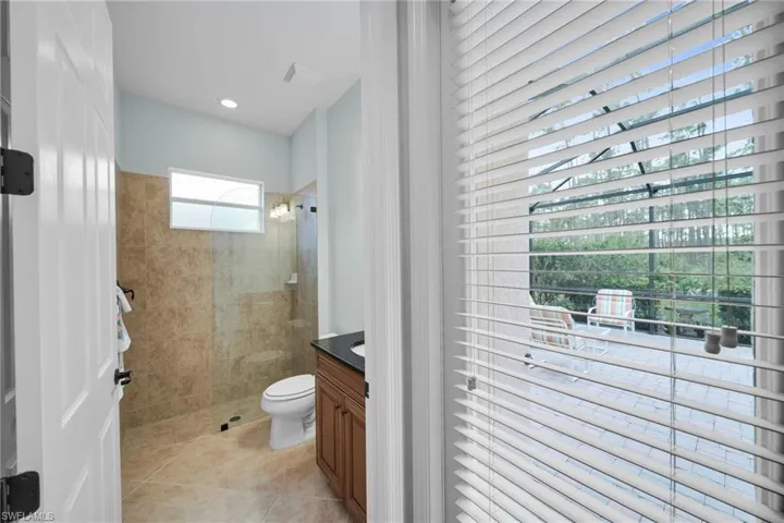 Full bathroom with walk in shower, vanity, and light tile patterned floors