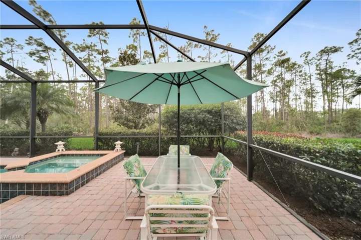 View of patio with glass enclosure, an in-ground hot tub, and a sunroom