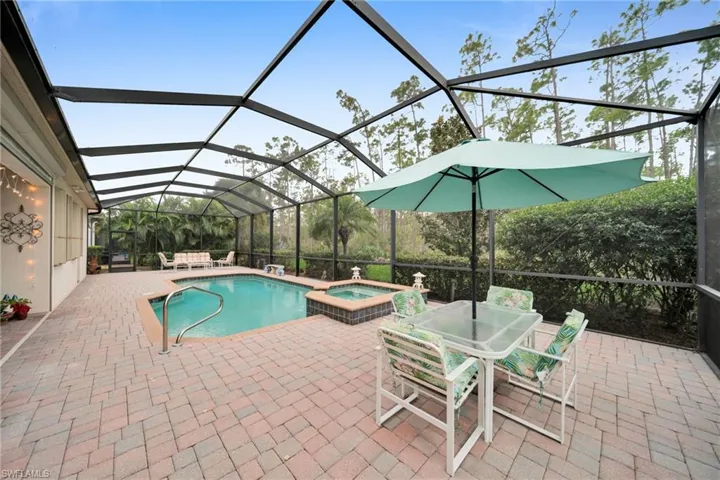 View of pool featuring a sunroom, outdoor dining space, a patio area, a lanai, and a pool with connected hot tub