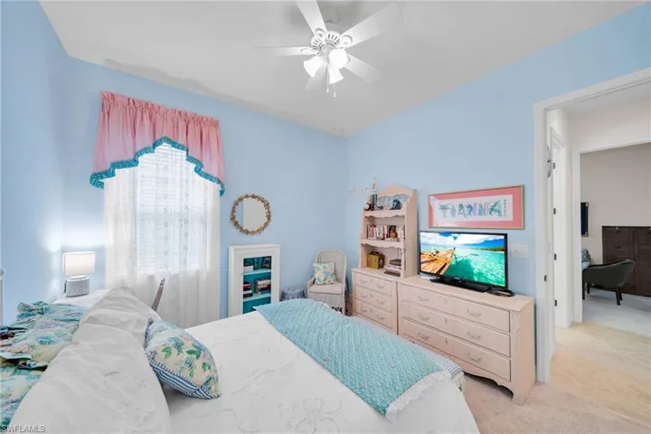 Carpeted bedroom with a ceiling fan