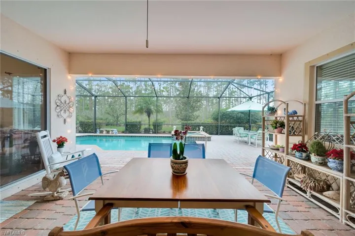 Swimming pool featuring outdoor dining space, a sunroom, a patio, and a lanai