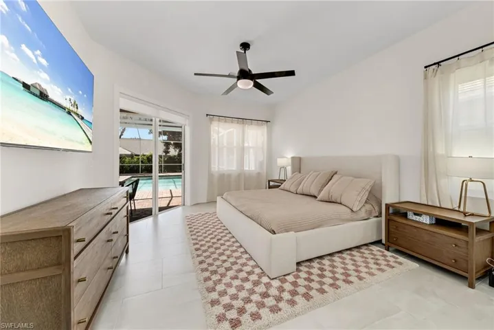Tiled bedroom featuring ceiling fan and access to outside