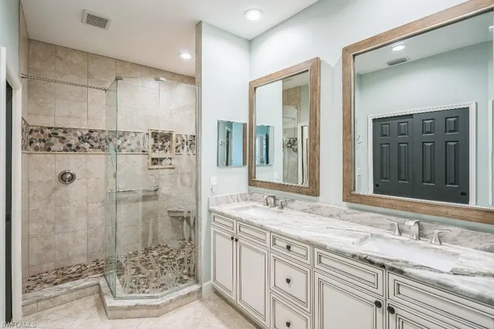 Bathroom with walk in shower, vanity, and tile patterned floors