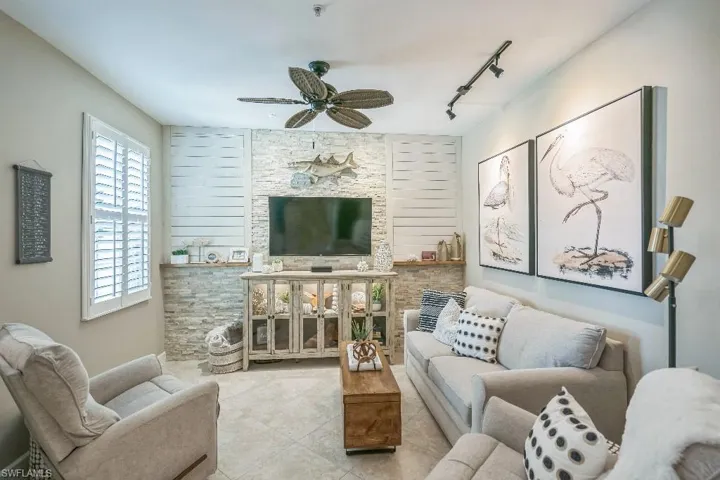 Living room with rail lighting, light tile patterned floors, and ceiling fan