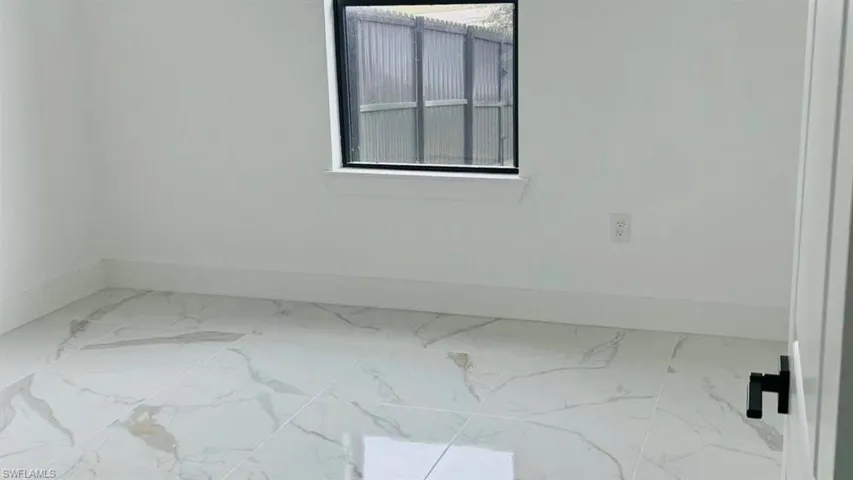 Unfurnished room with tile finish floors and baseboards