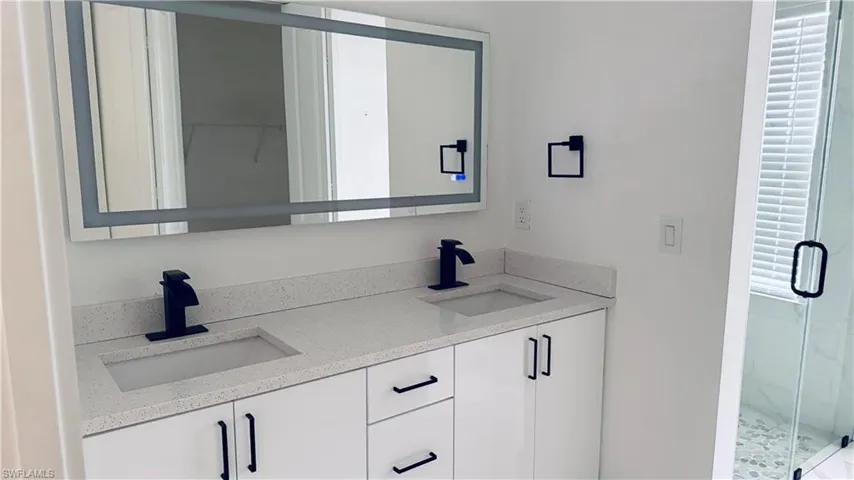 Full bath with double vanity and a stall shower