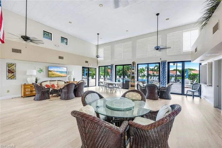Dining area featuring light wood-type flooring, ceiling fan, and a towering ceiling