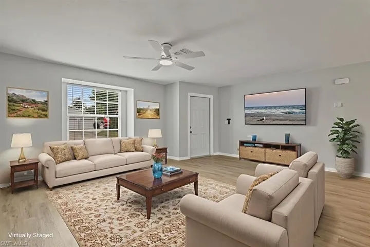 Living room with light wood-style flooring and a ceiling fan