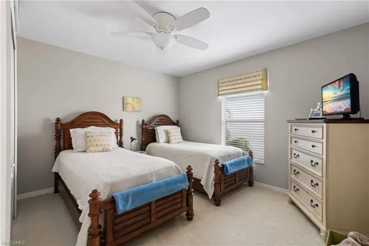 Bedroom featuring ceiling fan, baseboards, and light carpet