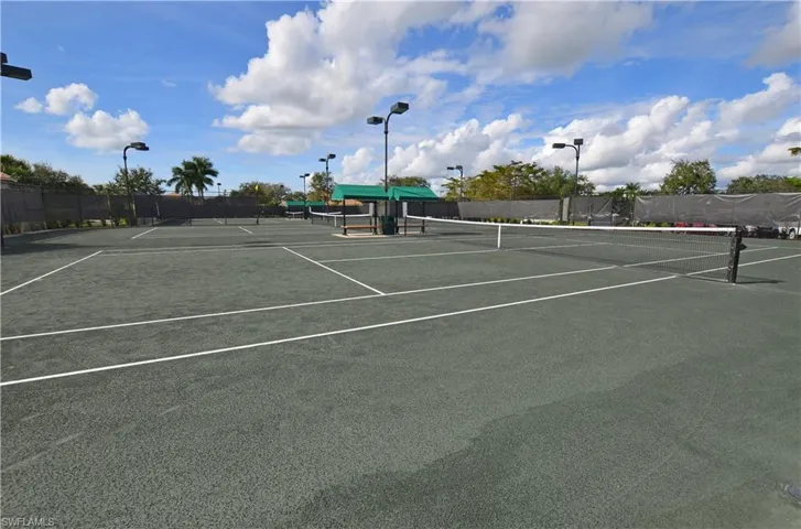 View of tennis court featuring fence