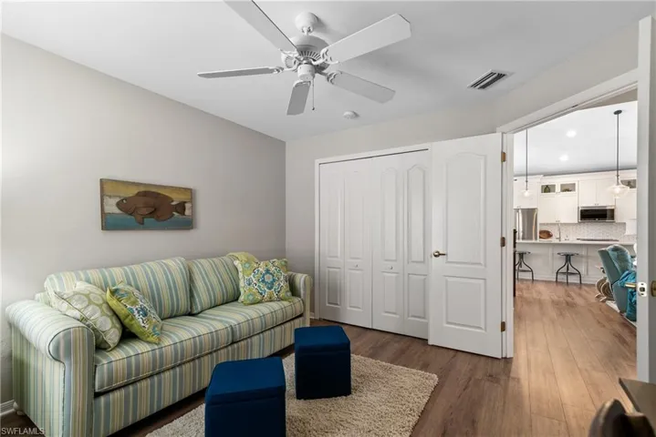 Living room featuring a ceiling fan, wood finished floors, visible vents, and recessed lighting